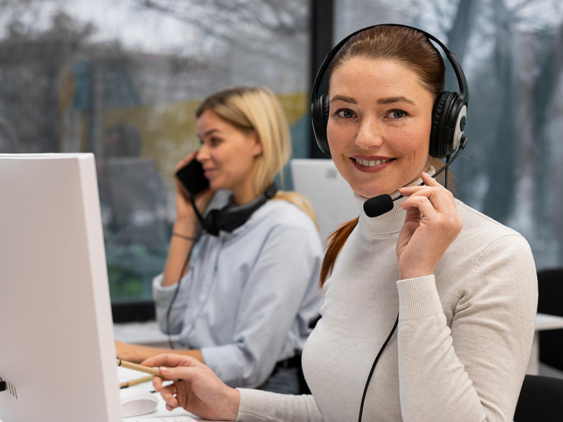Zwei Damen, die in einem Callcenter arbeiten und per Headset die Kunden bedienen